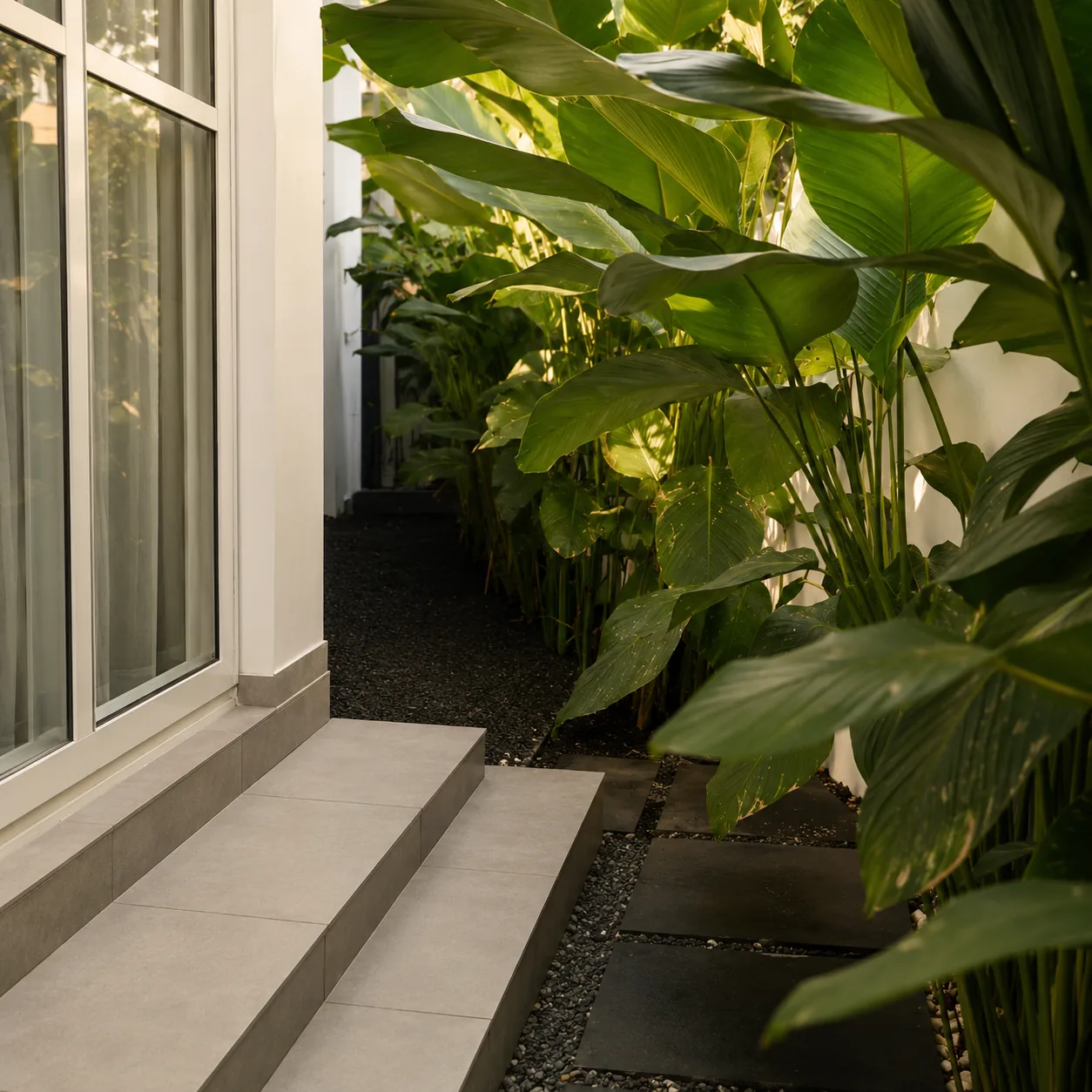 Tropical planting corridor beside white architecture