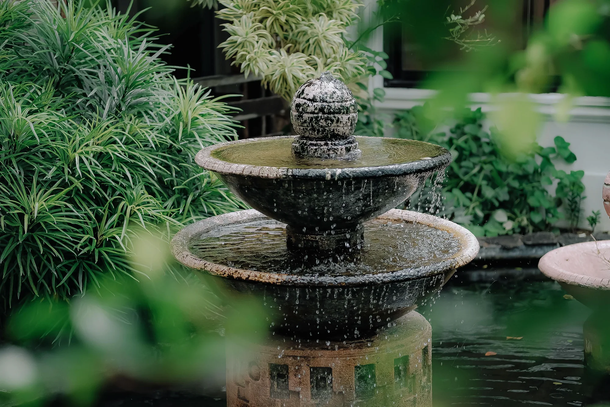 Two-tier stone fountain with a curtain of falling droplets