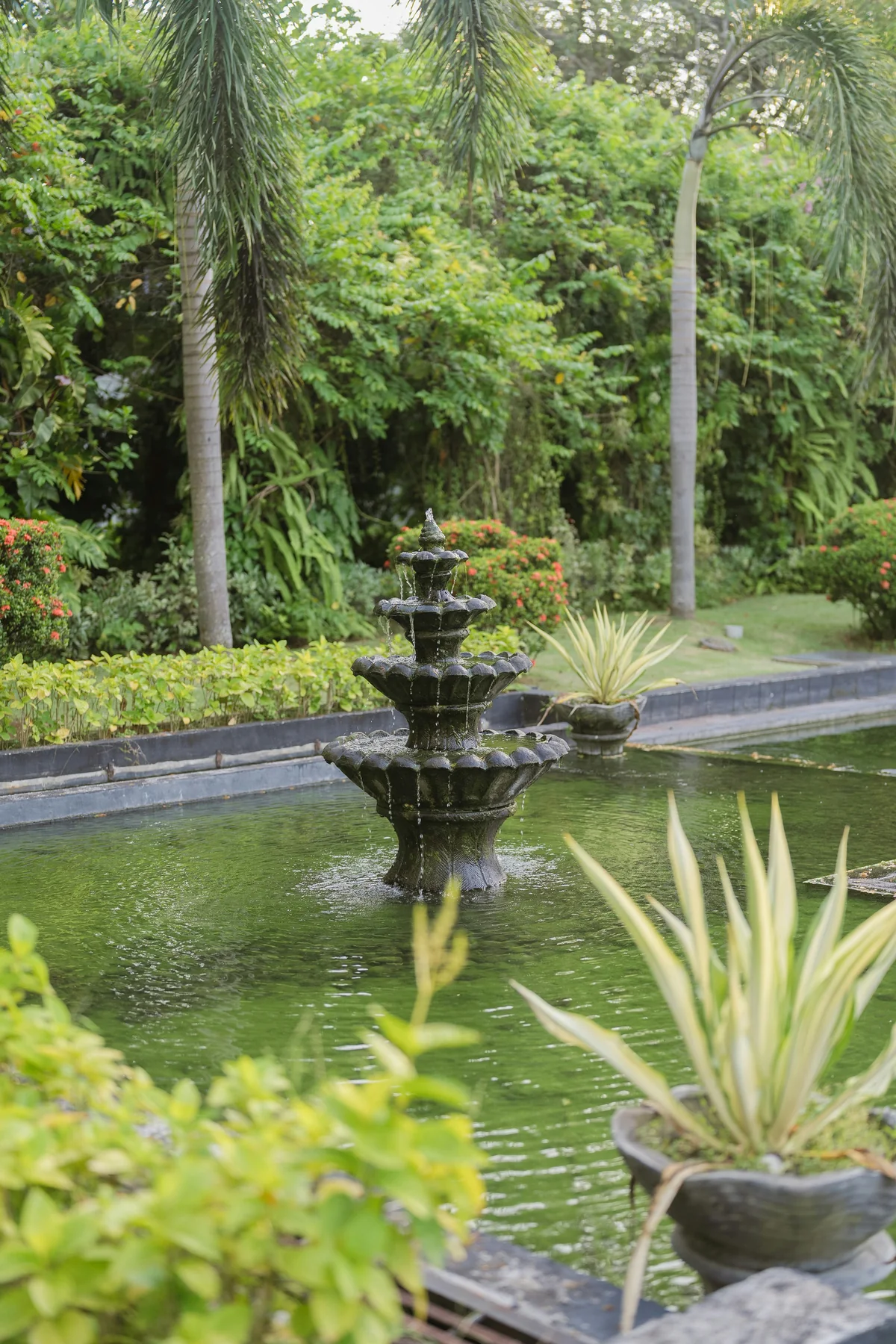 Three-tier stone fountain in a tropical garden pond