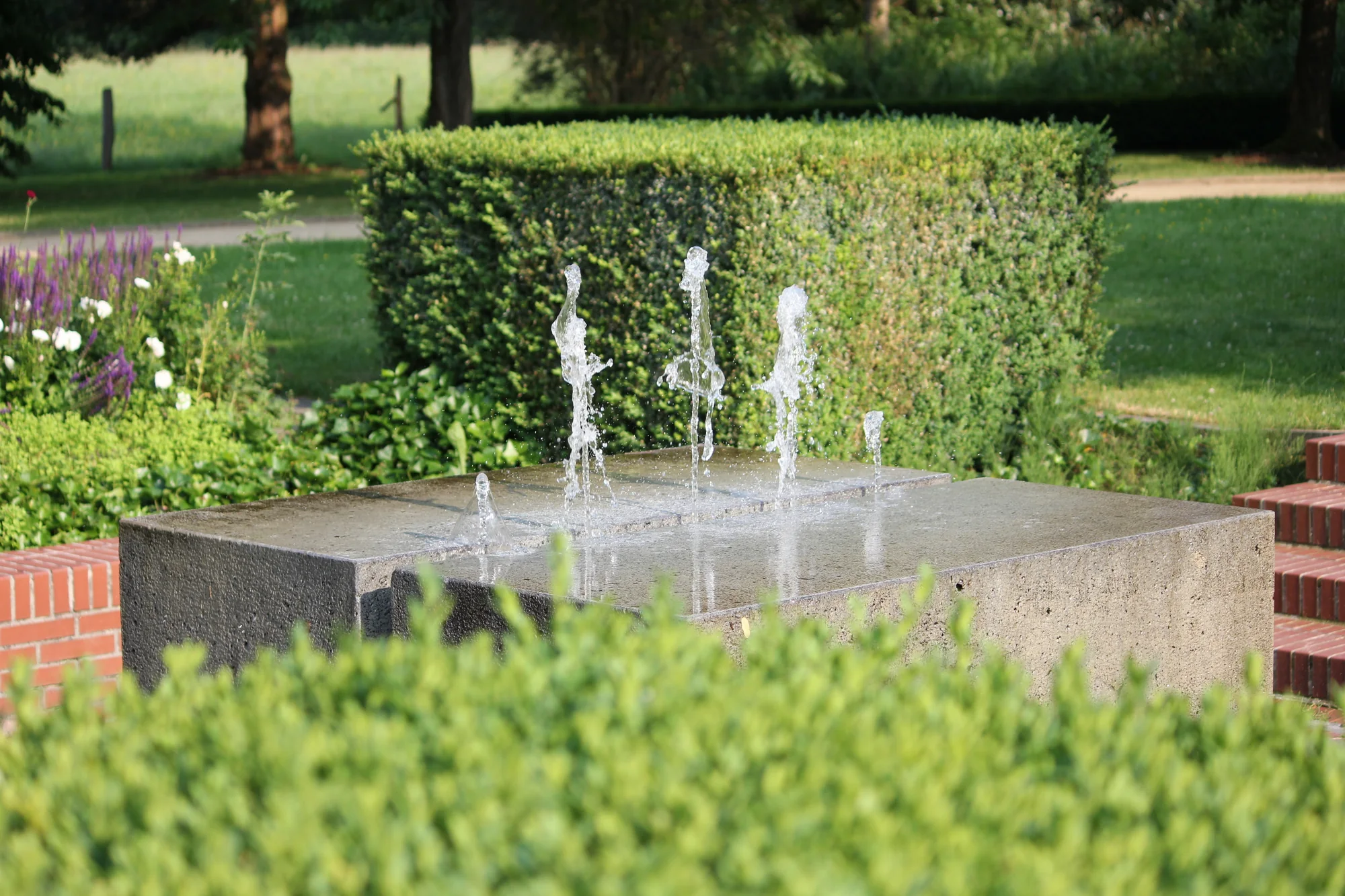 Modern concrete fountain with a cross channel and centre jets